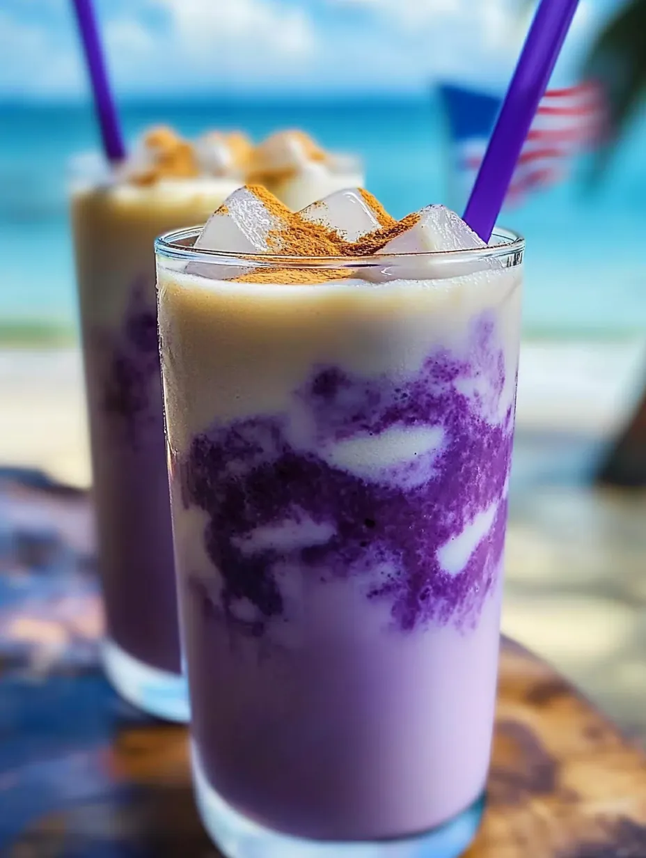 Single glass containing purple liquid with ice cubes and drinking straw.