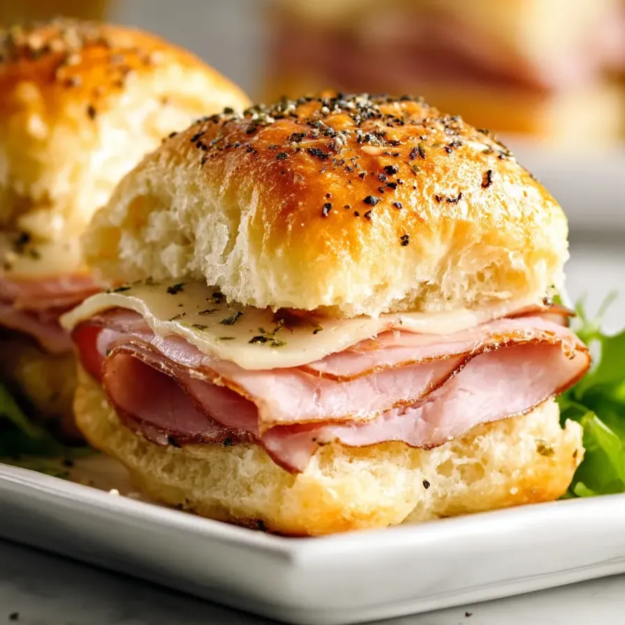 Two ham and cheese sandwiches on a plate.