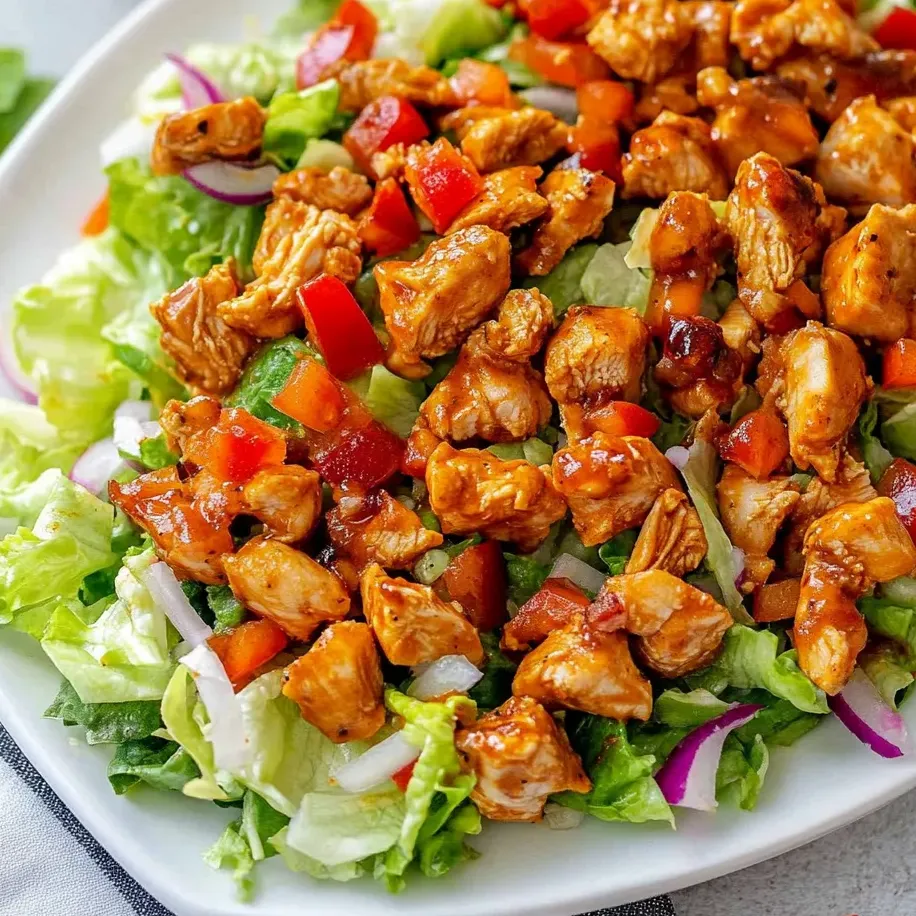 A plate of chicken salad with lettuce and tomatoes.