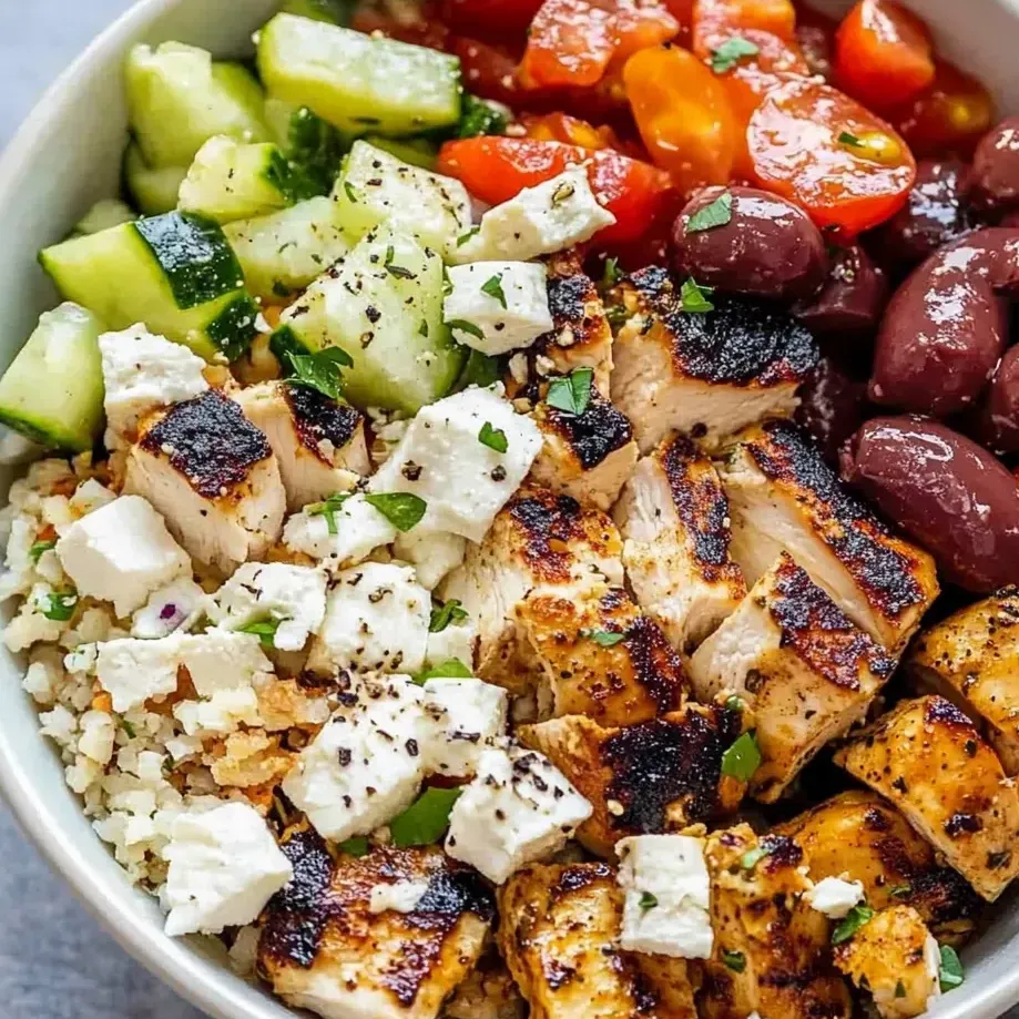 Chicken, tomatoes, cucumbers, and olives in a bowl.