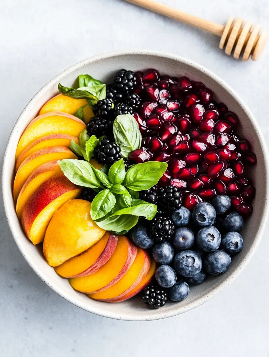 Bowl full of peaches, raspberries, blackberries, and blueberries.