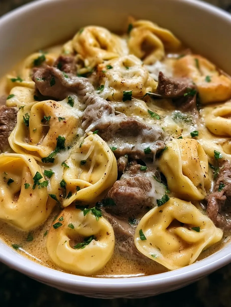 A bowl of cheesesteak tortellini in creamy provolone sauce recipe .
