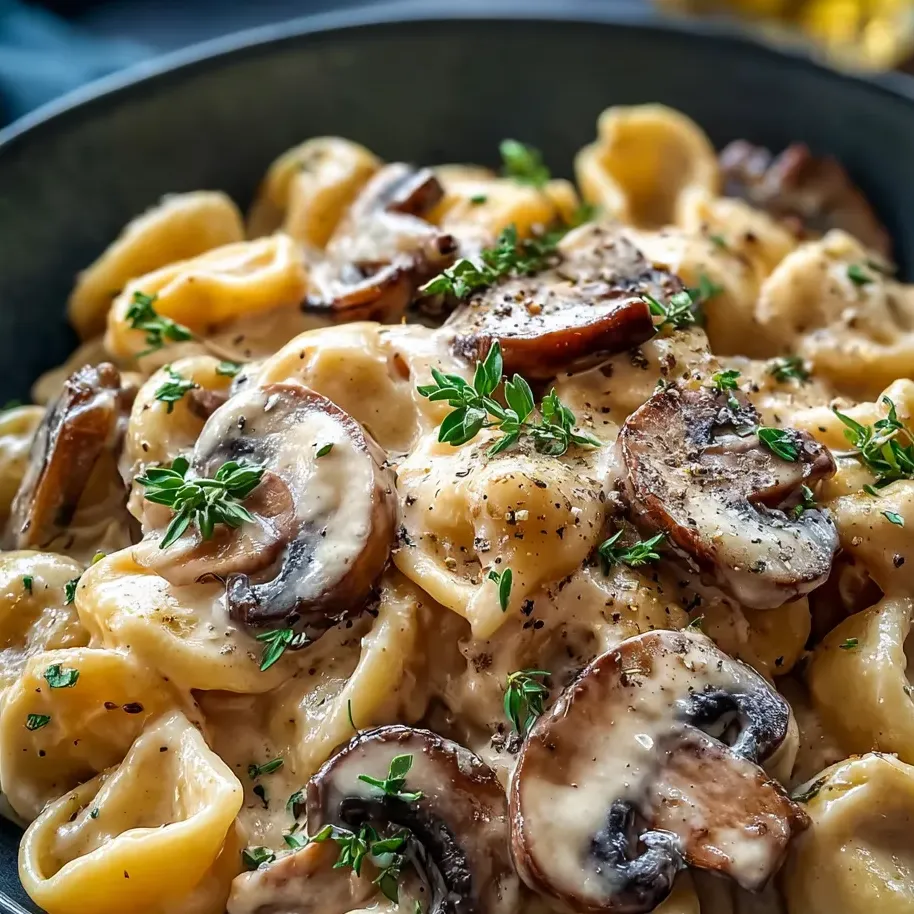 Pasta with mushrooms and fresh herbs in a bowl.
