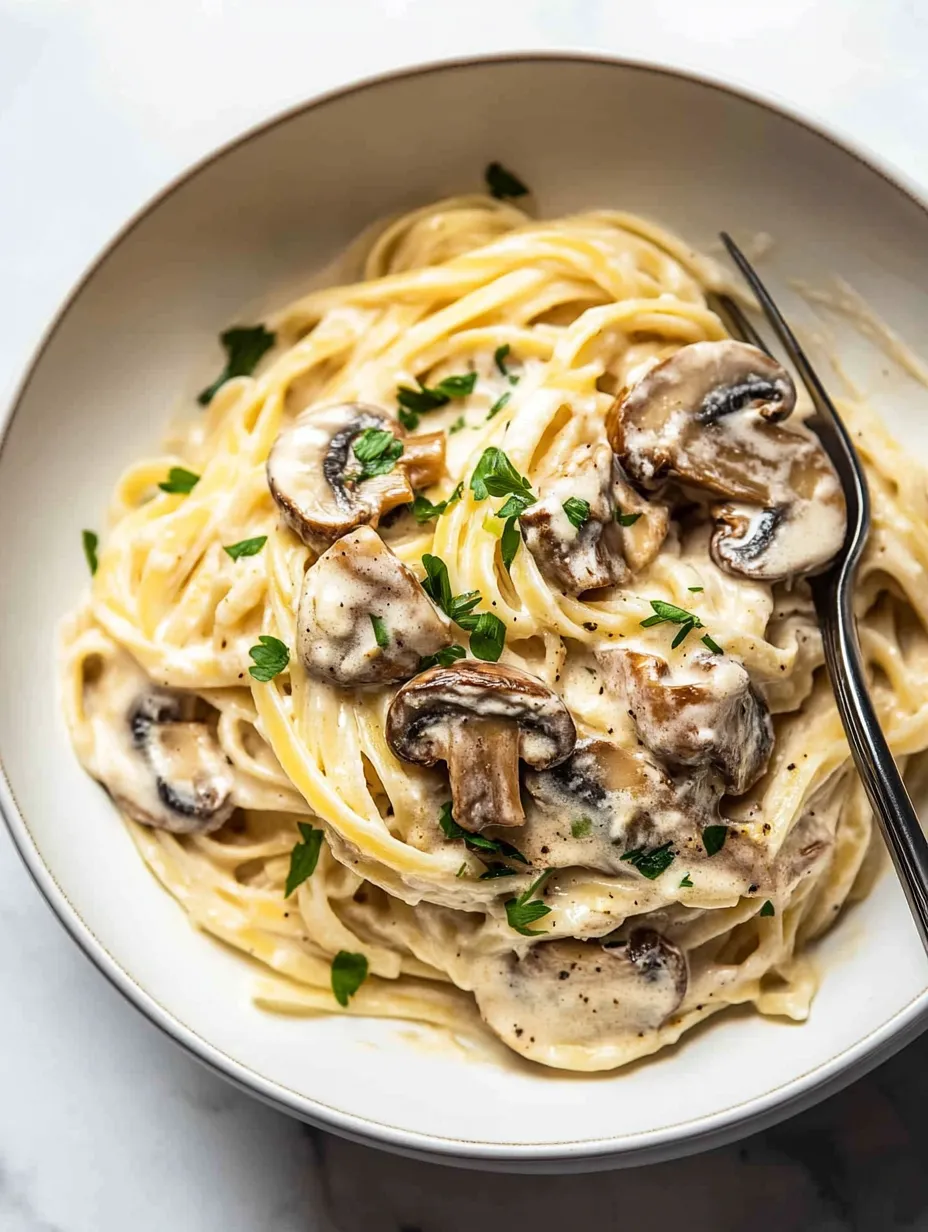 A bowl piled with noodles, mushrooms, and fresh herbs.