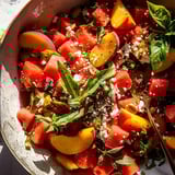 A vibrant mix of peach and watermelon chunks in a bowl.