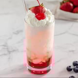 Italian cream soda served up in a glass with a cherry topping.