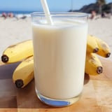 Glass filled with creamy Korean banana milk sitting on a table.