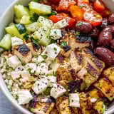 Chicken, tomatoes, cucumbers, and olives in a bowl.
