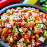 Salsa in a bowl with chopped tomatoes, onions, and peppers.